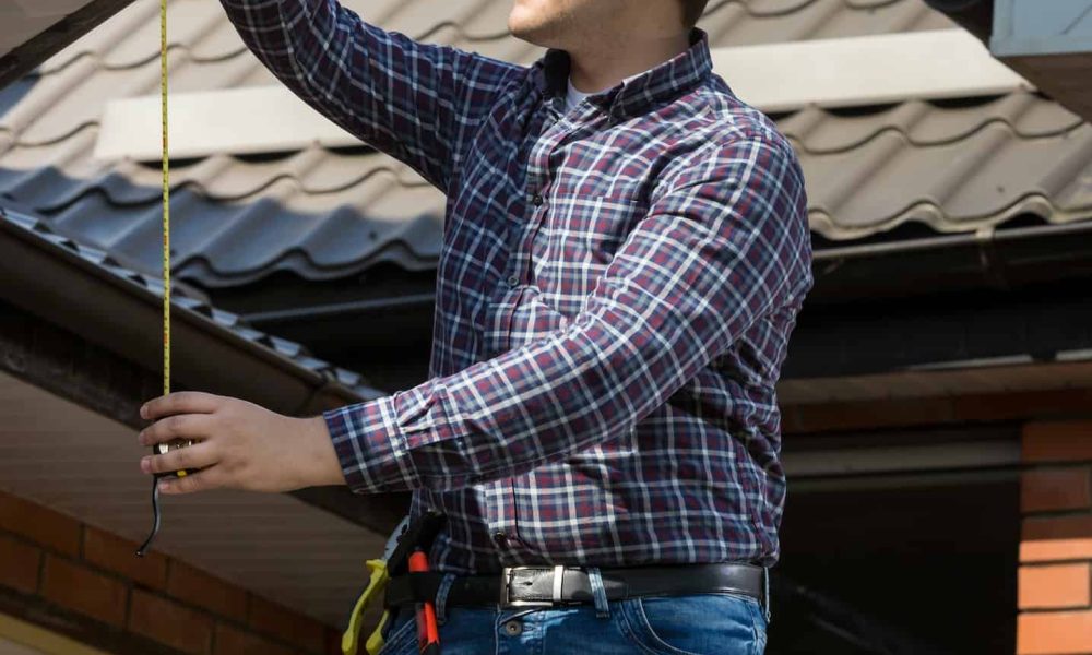 professional-worker-measuring-height-of-roof-with-tape.jpg